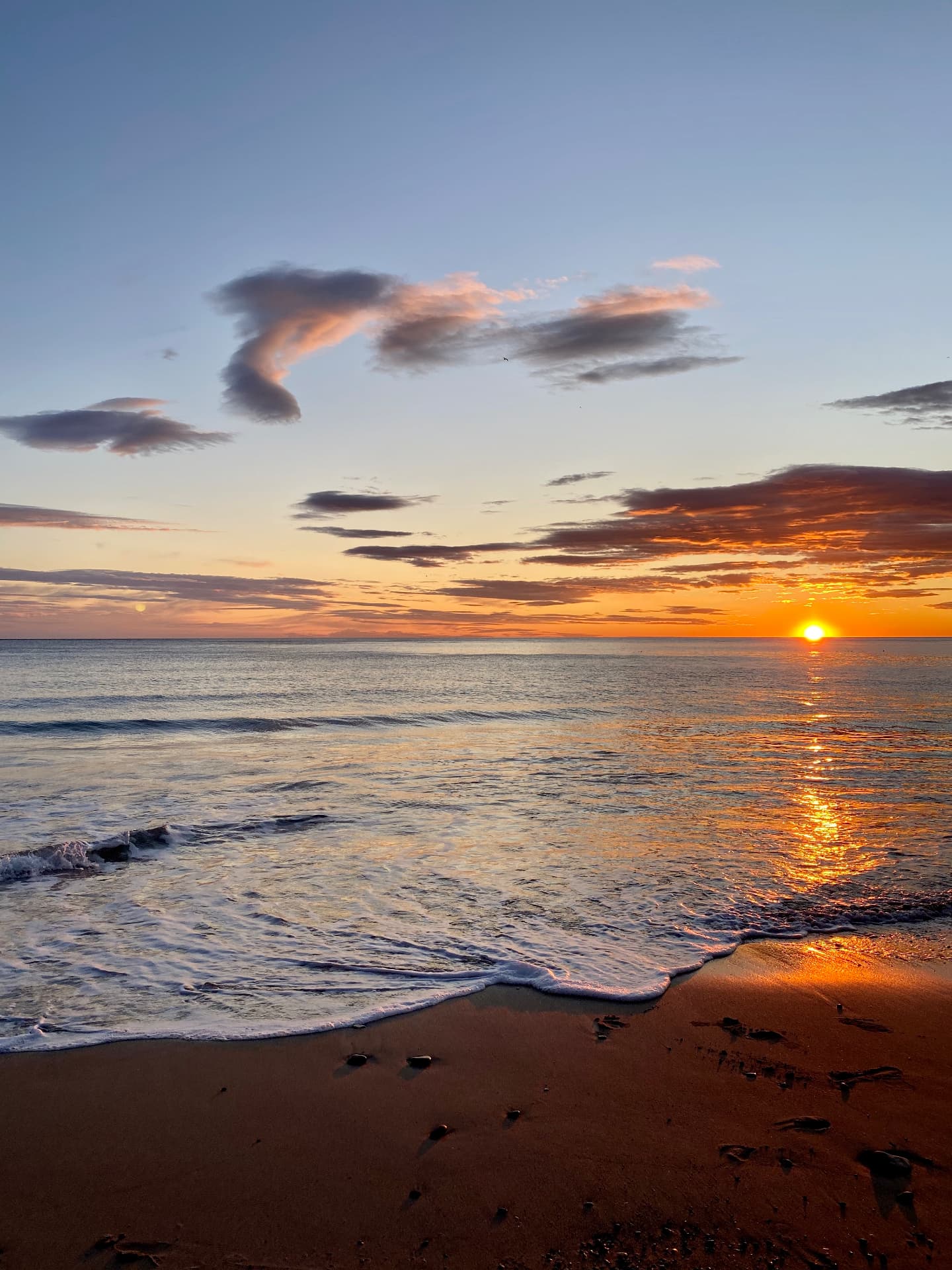 Sunset reflected in waves along a beach