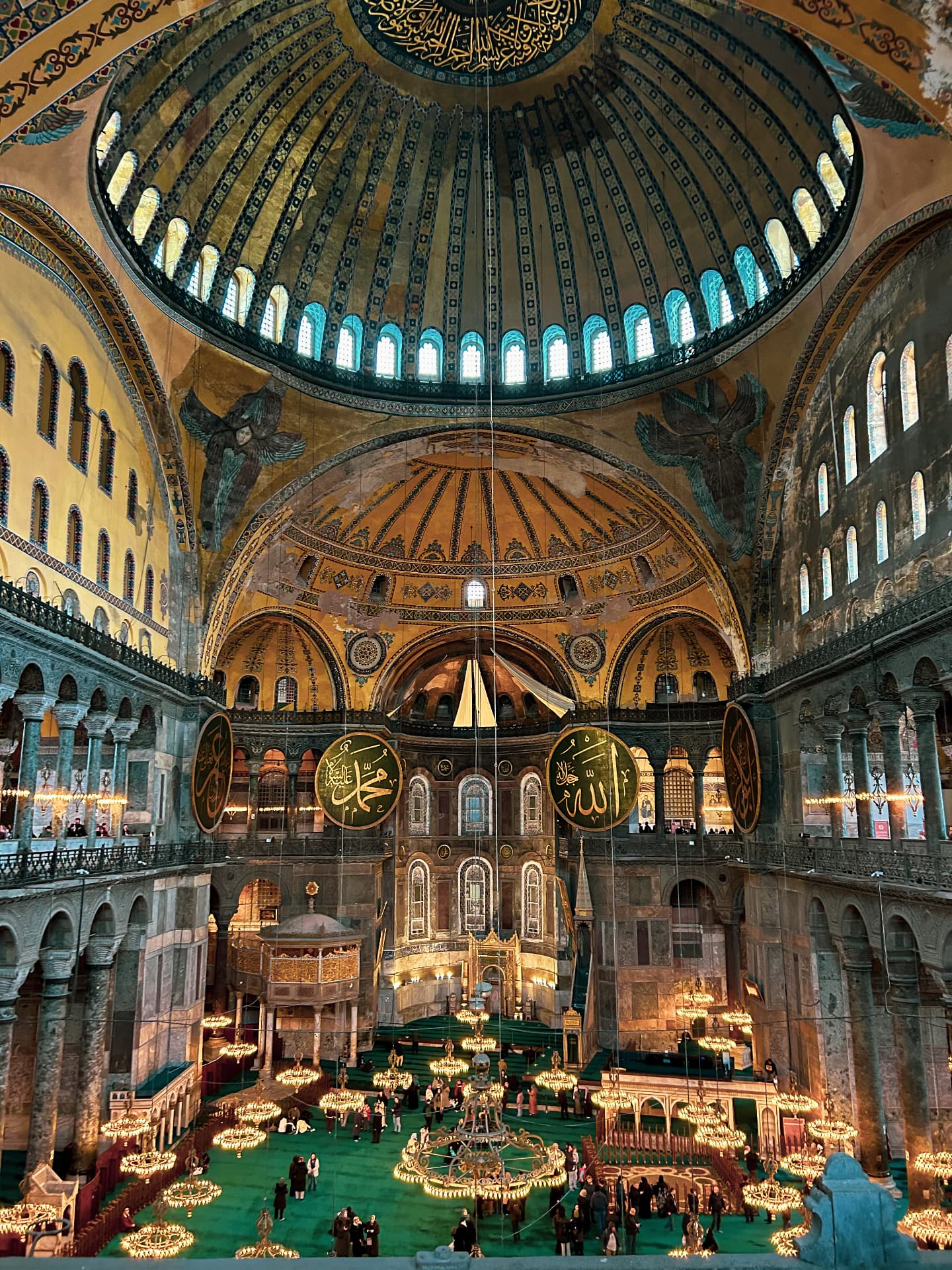 Hagia Sophia's ornate domes, calligraphy and softly glowing chandeliers in Istanbul