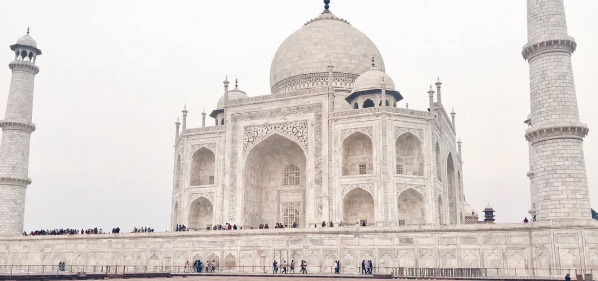 The Taj Mahal's pale marble dome and carved arches seen close up in soft light