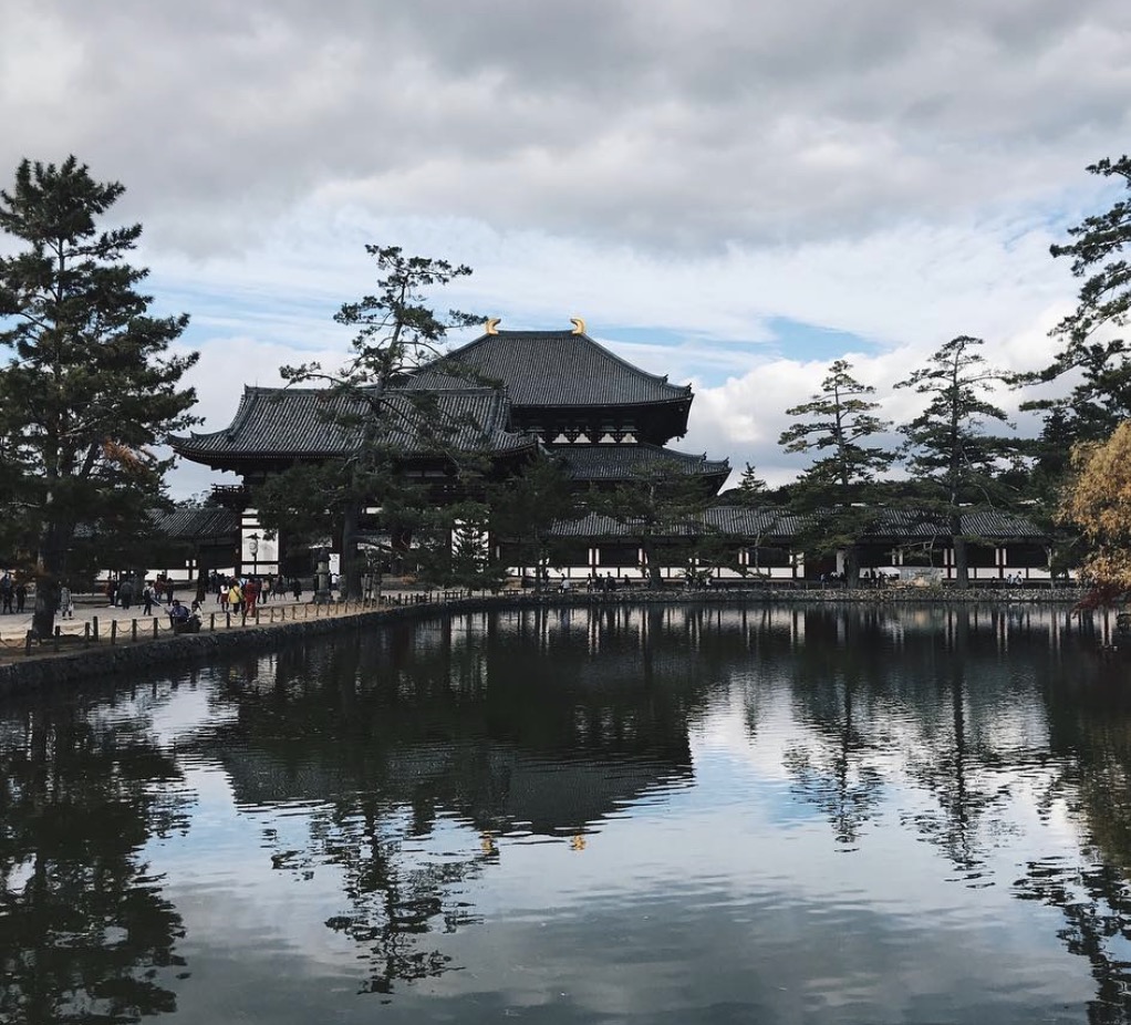 The Great Buddha Hall of Tōdai-ji in Nara reflected in a still pond beneath drifting clouds